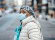 Nurse in mask crossing road in city